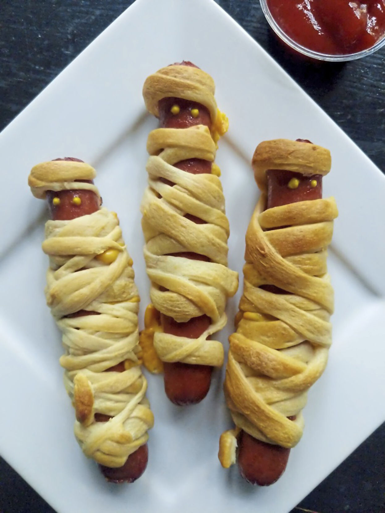 Little ghouls and goblins will love these crescent roll-wrapped mummy dogs.